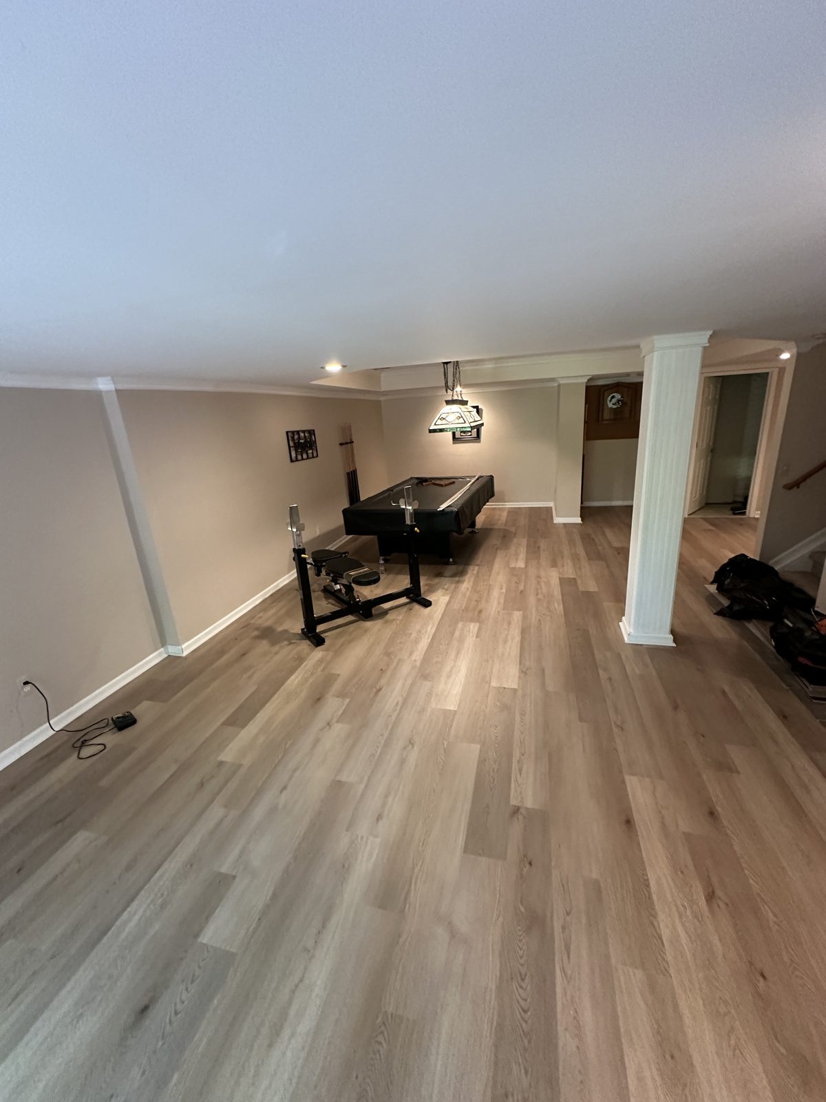 Finished basement with light oak-look luxury vinyl plank flooring and a pool table