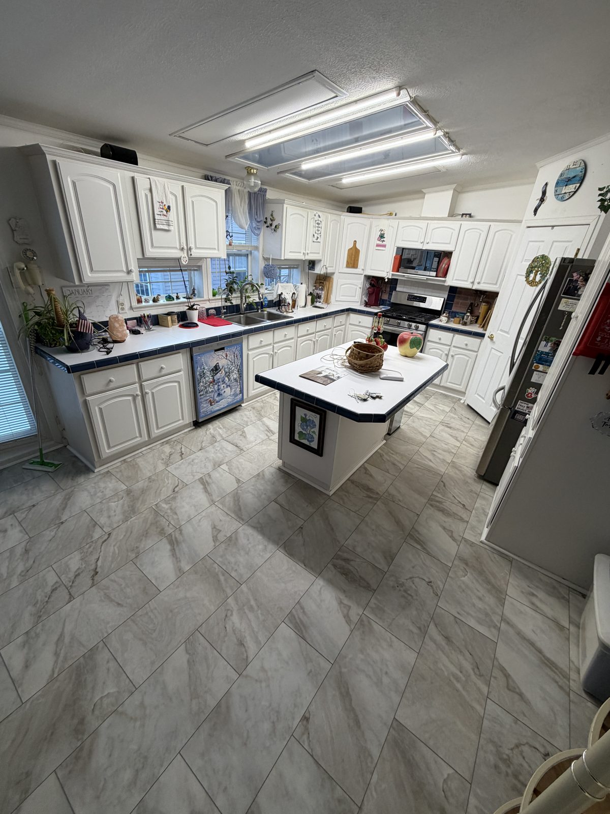 Kitchen with large light grey marble-look floor tiles laid in a staggered pattern